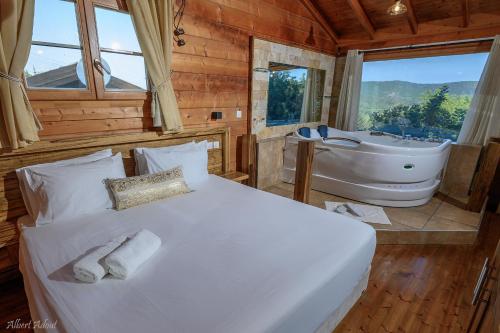 a bedroom with a bed and a tub in a room at Lev Hahoresh Boutique Hotel in Shomera