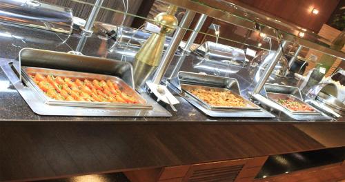 a buffet with several trays of food on a counter at Crowne Plaza Madinah by IHG in Al Madinah