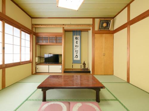 a room with a table in the middle of a room at Tabist Sakipo Minamichita in Morozaki