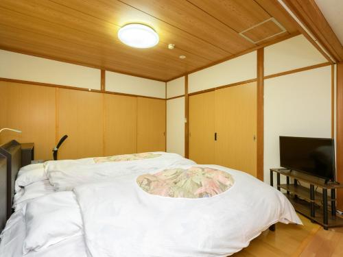 a room with a bed and a television in it at Tabist Sakipo Minamichita in Morozaki