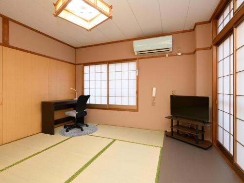 an empty room with a desk and a television at Tabist Sakipo Minamichita in Morozaki