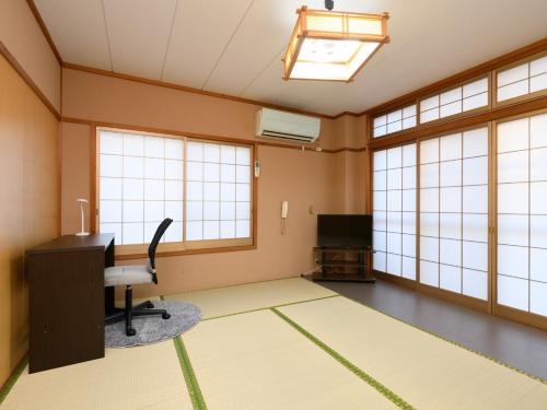 an office with a desk and a computer in a room with windows at Tabist Sakipo Minamichita in Morozaki