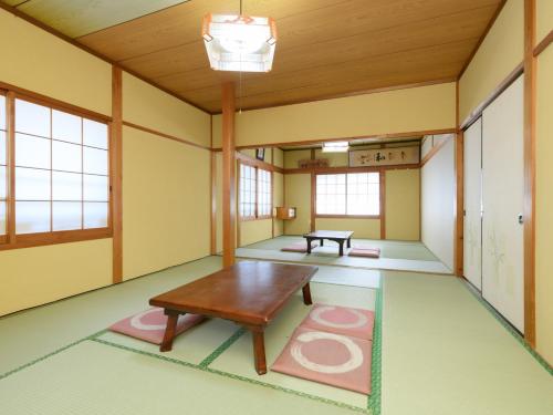 an empty room with a table and a bench at Tabist Sakipo Minamichita in Morozaki