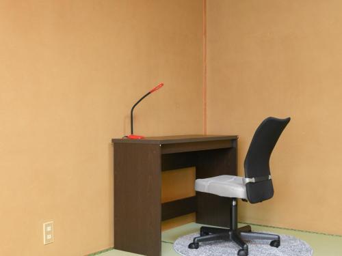 an office with a desk with a chair and a lamp at Tabist Sakipo Minamichita in Morozaki