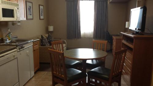a kitchen with a small table and chairs and a kitchen with a kitchen at Days Inn & Suites by Wyndham West Edmonton in Edmonton