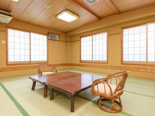 a large room with a table and chairs in it at Tabist Sakipo Minamichita in Morozaki