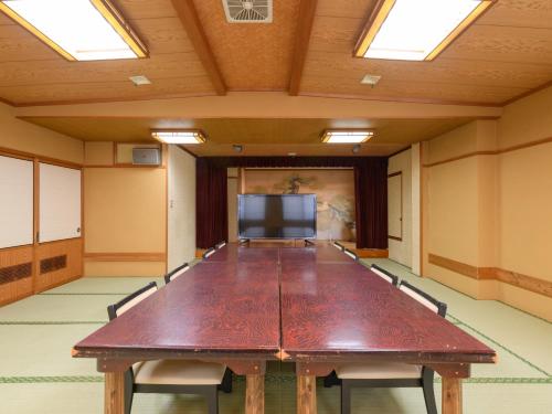 a conference room with a long table and a tv at Tabist Sakipo Minamichita in Morozaki