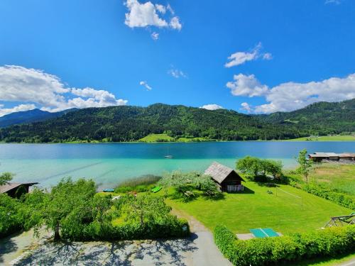 an aerial view of a lake with a house at Ferienhof Obergasser und Bergblick in Weissensee