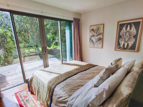 1 dormitorio con cama y ventana grande en Kia Noho, en Havelock North