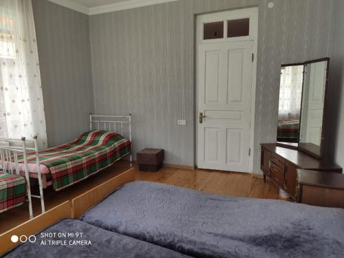 a bedroom with two beds and a mirror and a door at Family house in Racha, Oni in Oni