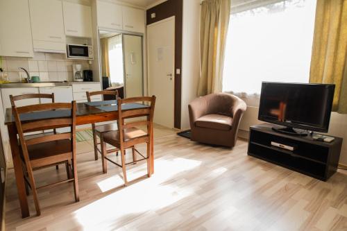 a living room with a dining table and a kitchen at Motelli Rovaniemi in Rovaniemi