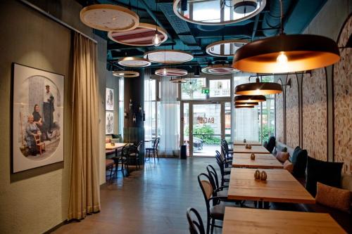 un ristorante con tavoli e sedie in legno e luci di AMERON Luzern Hotel Flora a Lucerna