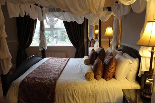 Un dormitorio con una cama grande con almohadas. en Adare Country House en Adare