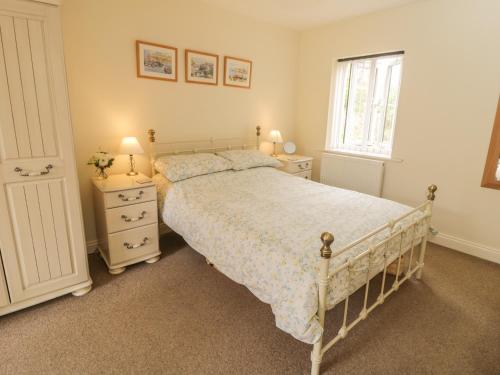 a bedroom with a bed and two night stands and a window at White Goose Cottage in Whitby