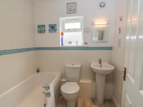 a white bathroom with a toilet and a sink at White Goose Cottage in Whitby
