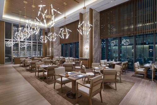 a dining room with tables and chairs and chandeliers at The Okura Heritage Tokyo in Tokyo