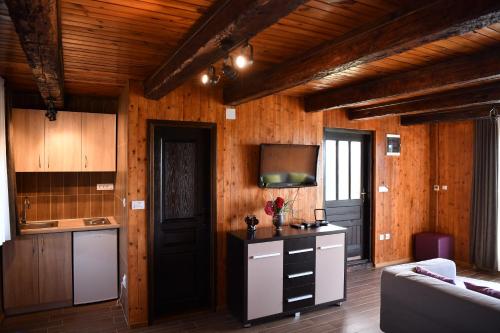 a kitchen with wooden walls and a couch in a room at Etno selo Moj Zavičaj in Gornji Milanovac