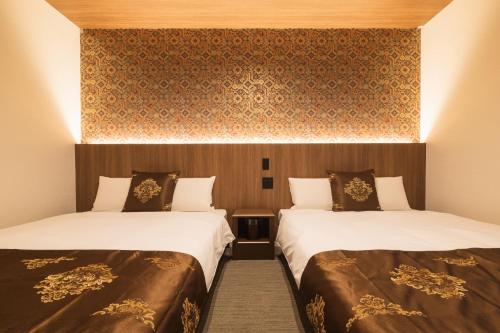a hotel room with two beds and a wall at GRAND BASE Nagasaki Chukagai in Nagasaki