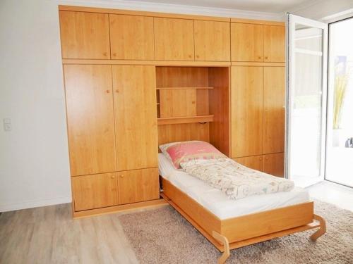 a large wooden cabinet with a bed in a room at Seedeich Apartment in Cuxhaven