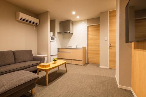 a living room with a couch and a table at GRAND BASE Nagasaki Chukagai in Nagasaki