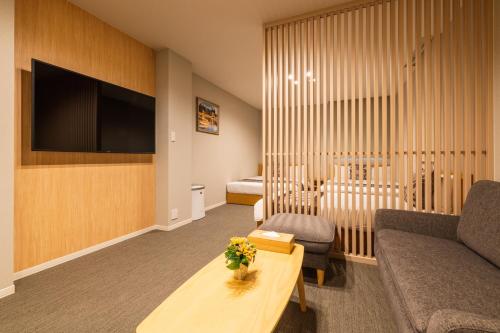 a living room with a couch and a tv at GRAND BASE Nagasaki Chukagai in Nagasaki