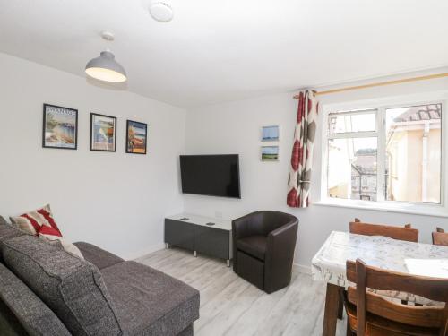 a living room with a couch and a tv at Swanage Town Apartment in Swanage