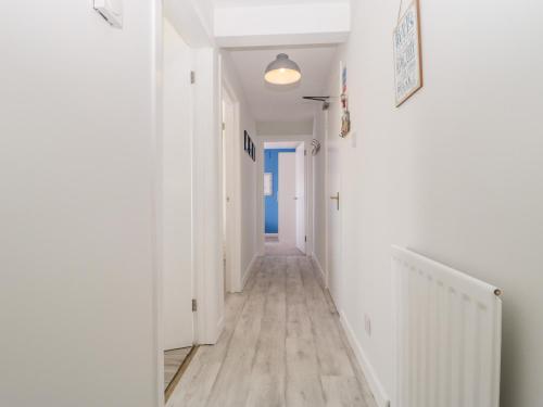 an empty hallway with white walls and wooden floors at Swanage Town Apartment in Swanage