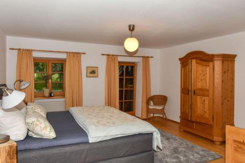 1 dormitorio con 1 cama y armario de madera en Stadlerhof, en Frasdorf
