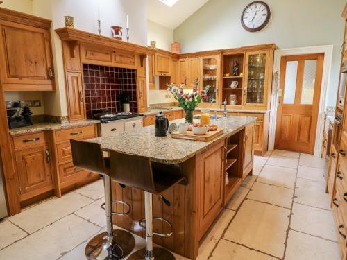 a kitchen with wooden cabinets and a granite counter top at Manor House in Accrington