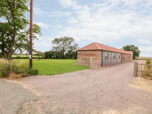 a brick building with a pole next to a field at The Stables in Boston