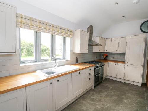 a kitchen with white cabinets and a sink at The Stables in Boston