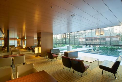 a restaurant with tables and chairs and a large window at The Okura Heritage Tokyo in Tokyo