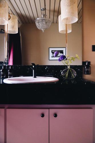 a bathroom with a sink and a vase of flowers at Isabella's House in Barcelona