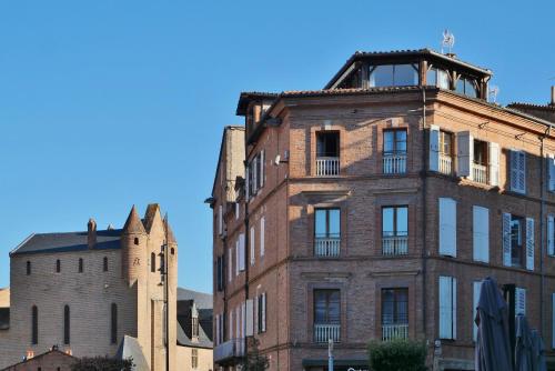 an old brick building next to a church at Chambre d'Elvire in Albi