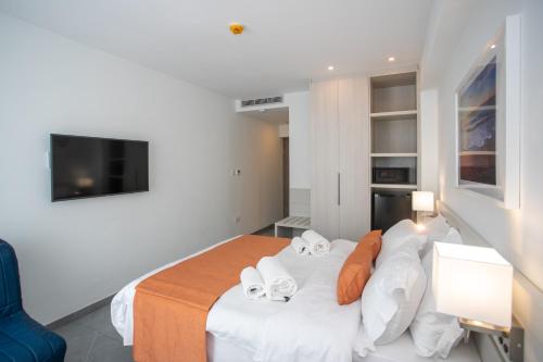 a bedroom with a bed with white sheets and orange pillows at Best Western Plus Larco Hotel in Larnaka