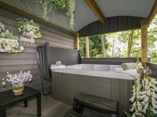 a bath tub in a room with a table at High Rigg Shepherd's Hideaway in Brampton