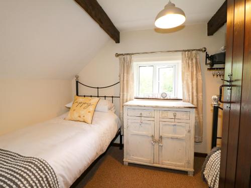 une petite chambre avec un lit et une fenêtre dans l'établissement Hoobrook Cottage, à Leek
