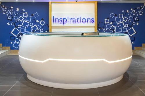 a white table with a sign that reads implications at Royal Swiss Lahore in Lahore