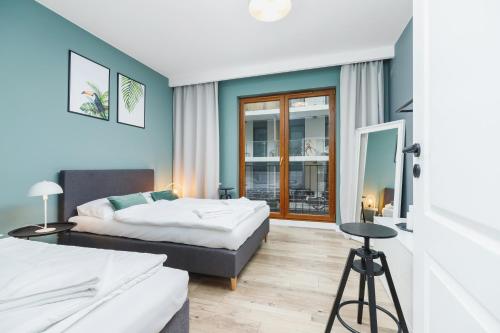 a hotel room with two beds and a window at Apartament 3d GO by Renters in Krakow