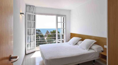 1 dormitorio con cama y ventana grande en Villa Reymar - diseño y vistas al mar en Tossa de Mar