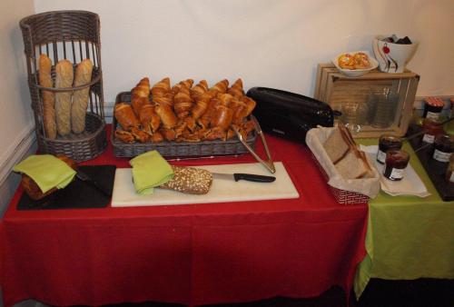 a table with a red table cloth with a basket of bread at Auberge Du Cheval Blanc in Baud