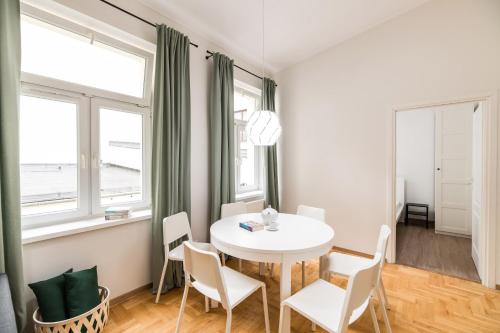 een witte eetkamer met een witte tafel en stoelen bij Native Apartments Czysta 5 in Krakau