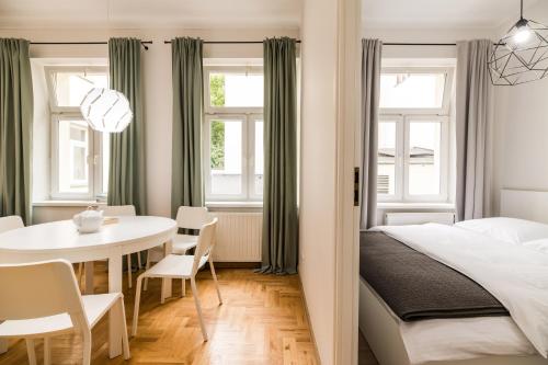 a bedroom with a bed and a table and a dining room at Native Apartments Czysta 5 in Kraków