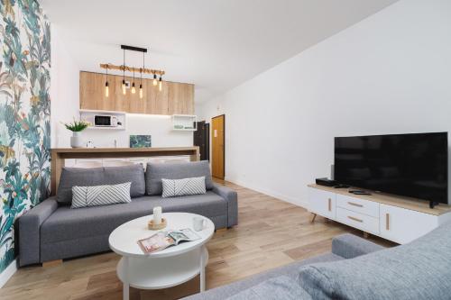 a living room with a couch and a tv at Apartament 3d GO by Renters in Krakow