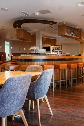 a restaurant with wooden tables and chairs and a bar at Seminaris Hotel Bad Honnef in Bad Honnef am Rhein