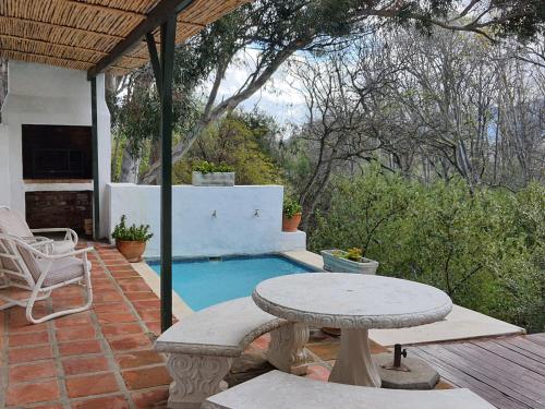 um pátio com uma mesa e uma piscina em Little Willow Brooke em Franschhoek
