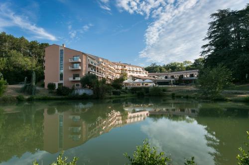 a building next to a body of water at Domaine Les Sources de Dieulefit in Dieulefit