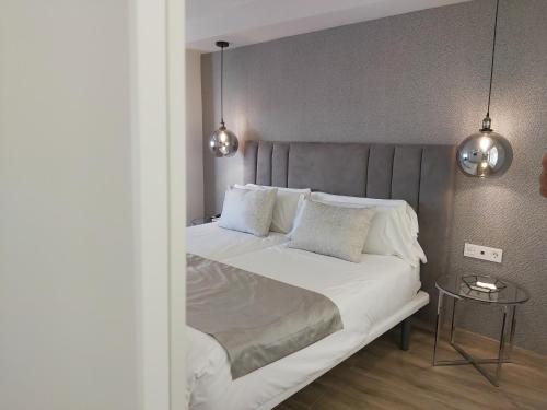 sypialnia z dużym łóżkiem z białą pościelą i poduszkami w obiekcie Del Parque Flats Flores Premium w Maladze