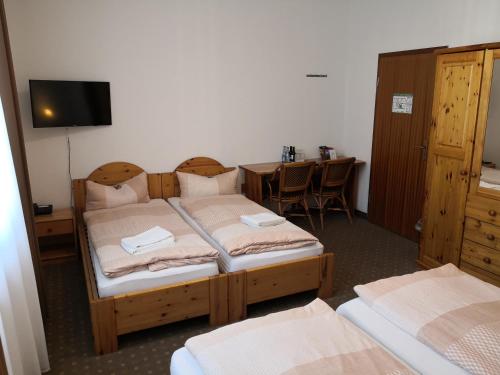 a bedroom with two beds and a desk and a table at Pension am Heusteig in Stuttgart