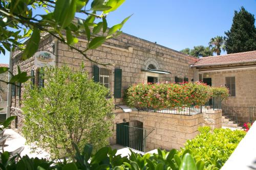 a brick building with a balcony with flowers on it at The Templer Inn in Jerusalem